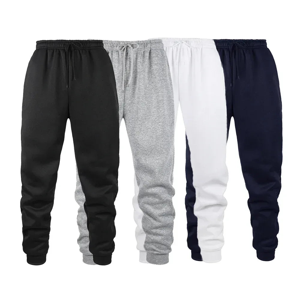 Four pairs of jogger pants in black, gray, white, and navy on a white background.