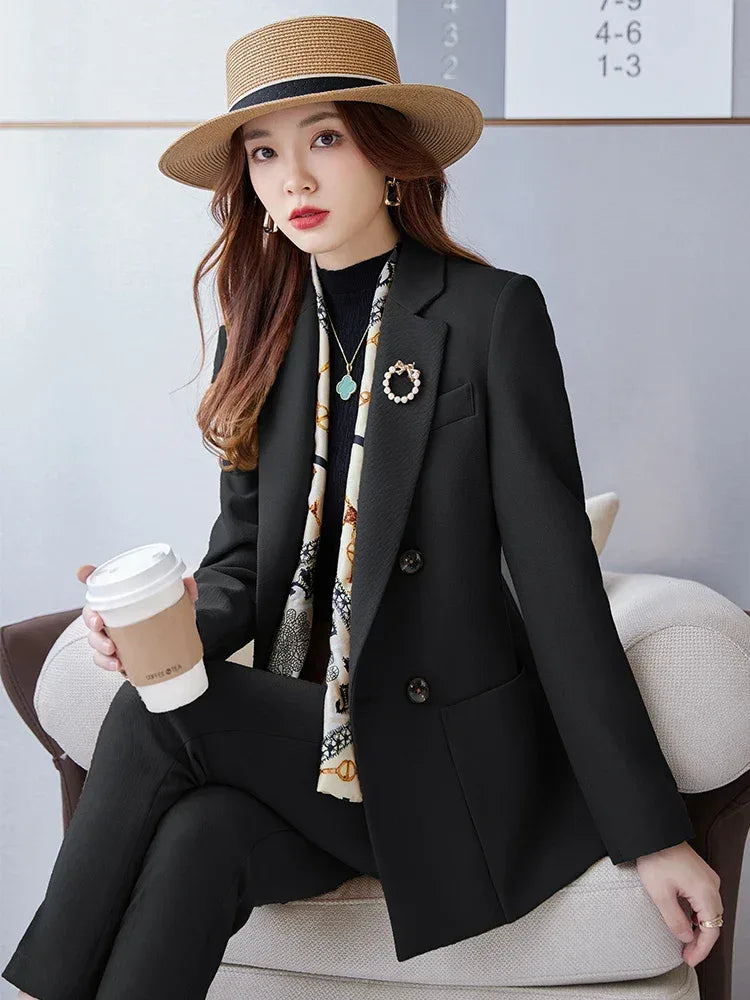Woman in a black blazer and hat holding a coffee cup, sitting on a couch.