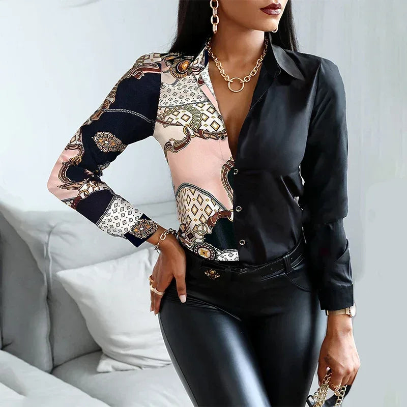 Woman wearing a patterned blouse with long sleeves and a black jacket over a white background