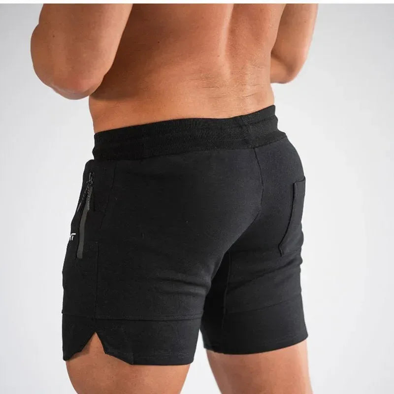 Black athletic shorts worn by a person on a white background