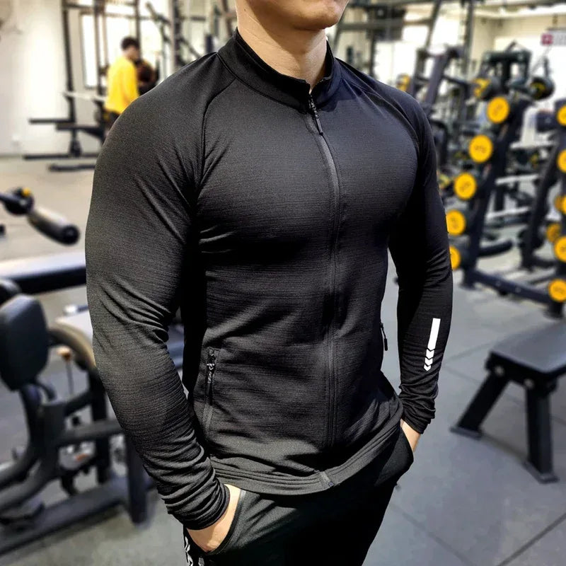 man in black jacket inside gym Front view of a men’s lightweight running jacket featuring a full-zip front and breathable quick-dry fabric- BetterPlace