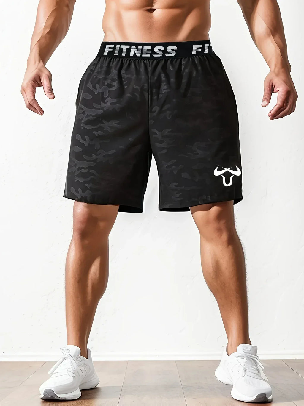 Black patterned fitness shorts with visible branding on a white background