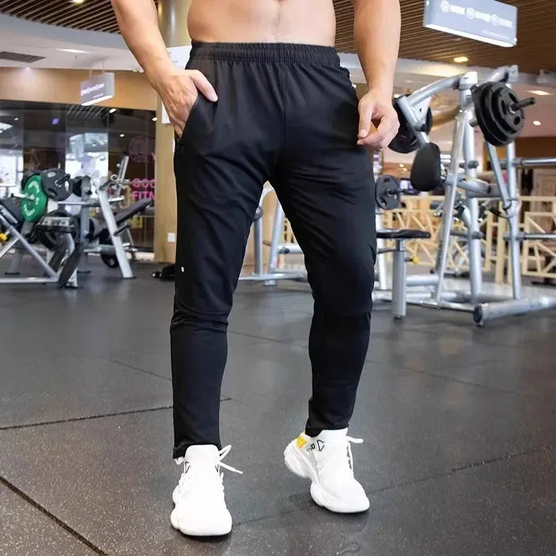 Person wearing black athletic pants and white sneakers in a gym setting