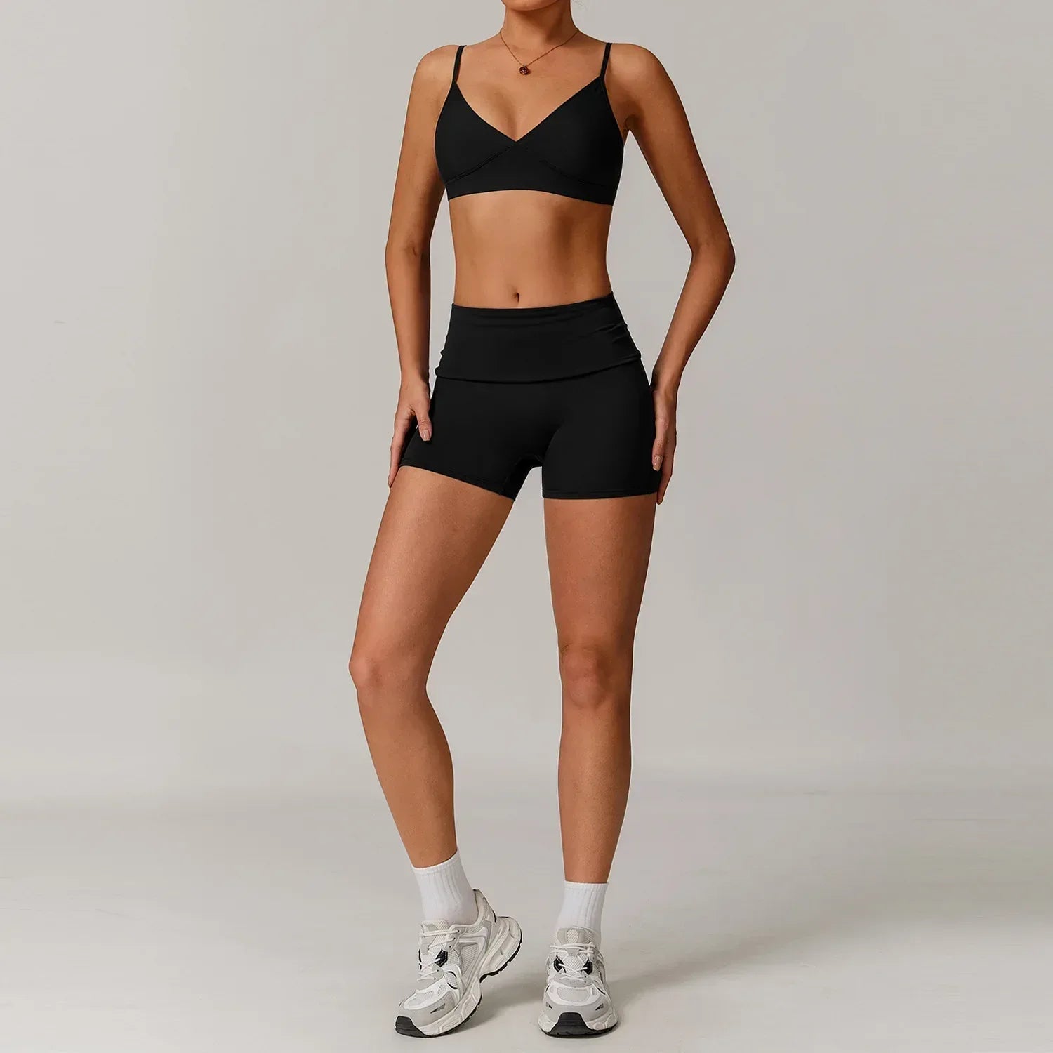 Woman wearing a black push up sports bra and high waisted scrunch butt shorts for a seamless booty lifting workout outfit - BetterPlace