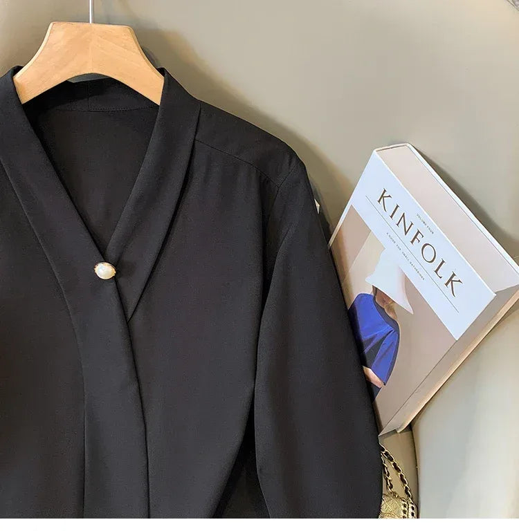 Black blazer on a hanger next to a 'KINFOLK' book
