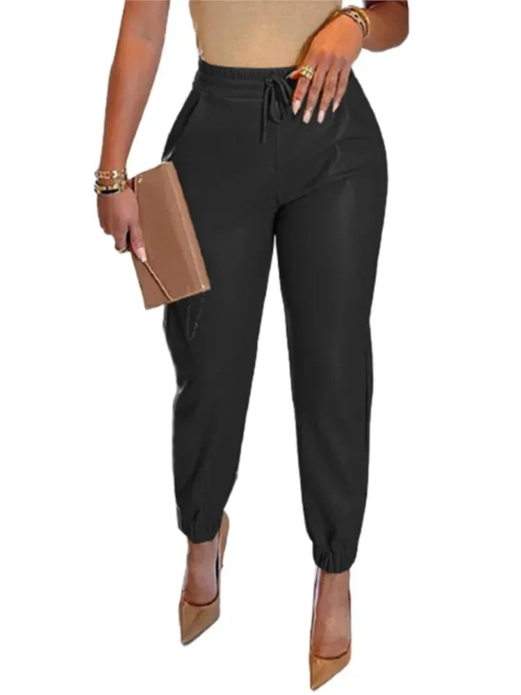 Black jogger pants worn by a person on a white background