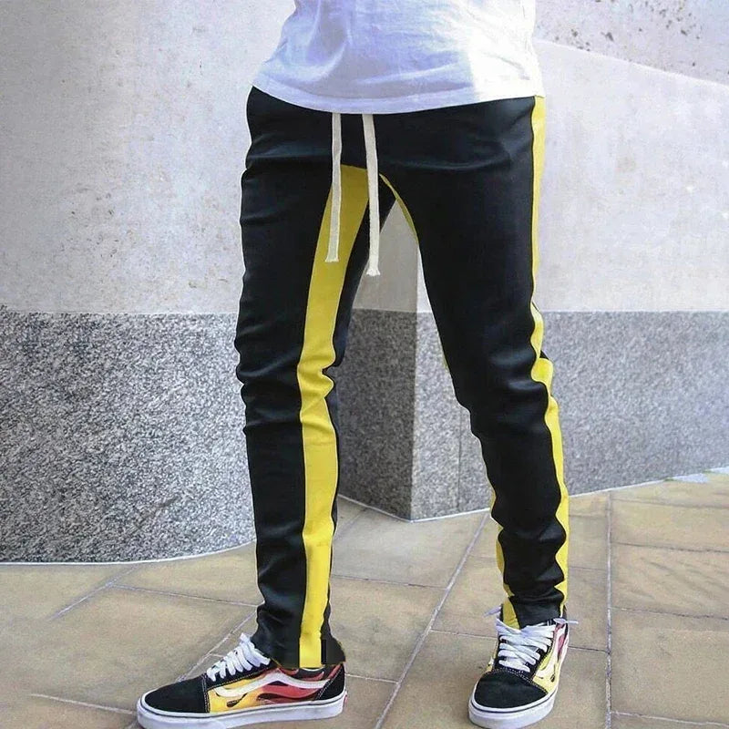 Black and yellow striped pants with a person wearing them, standing on a stone floor.