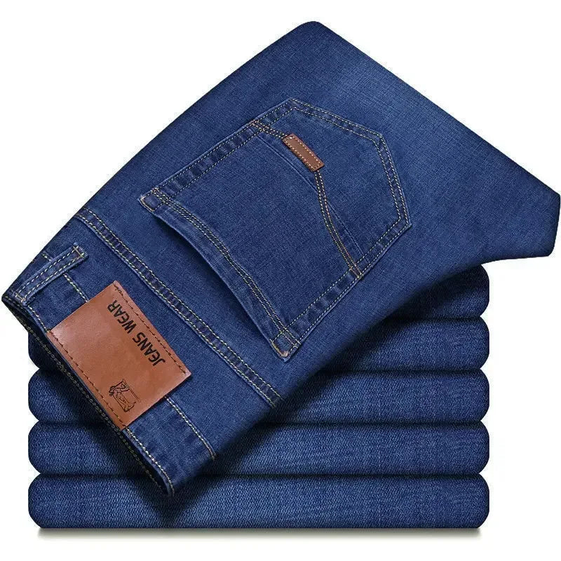 Stack of folded blue jeans with a brand label on a white background
