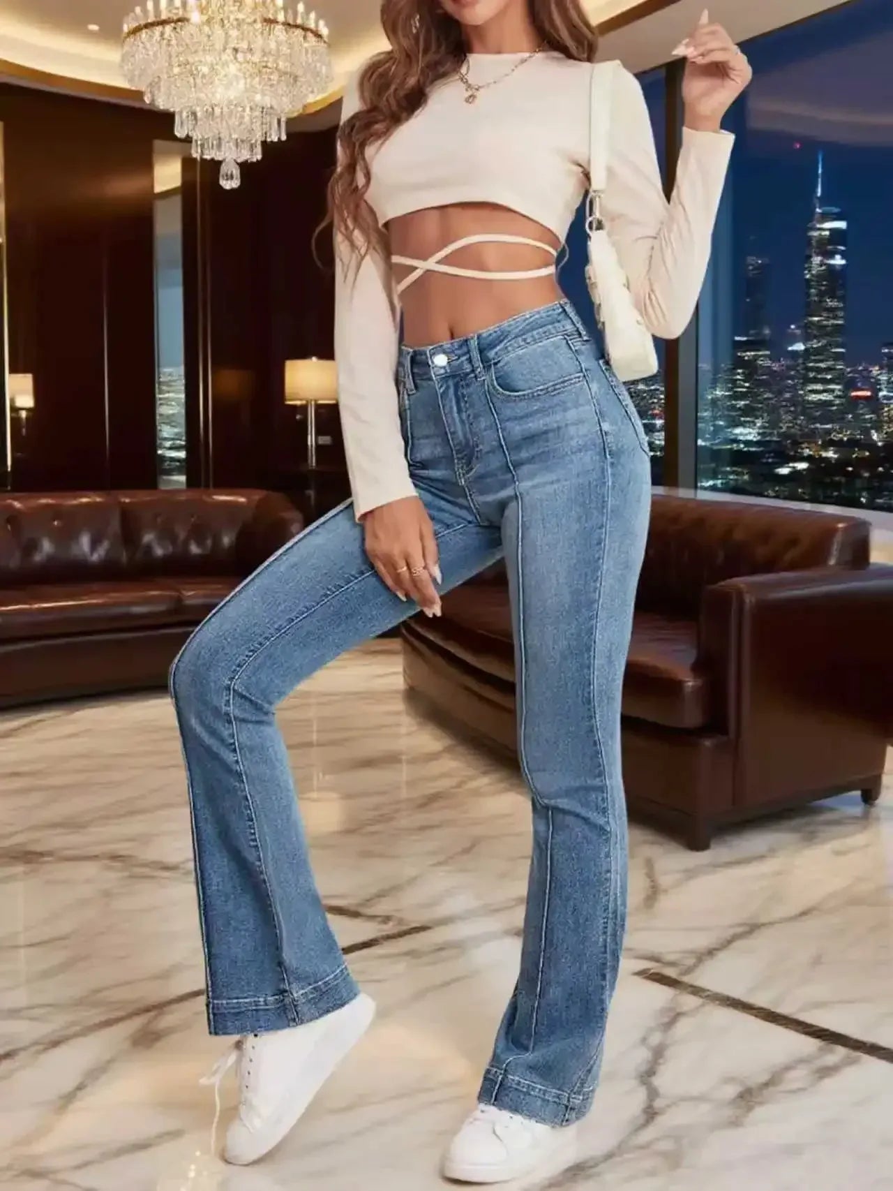 Person wearing blue jeans and a white top in an elegant interior setting with cityscape view.