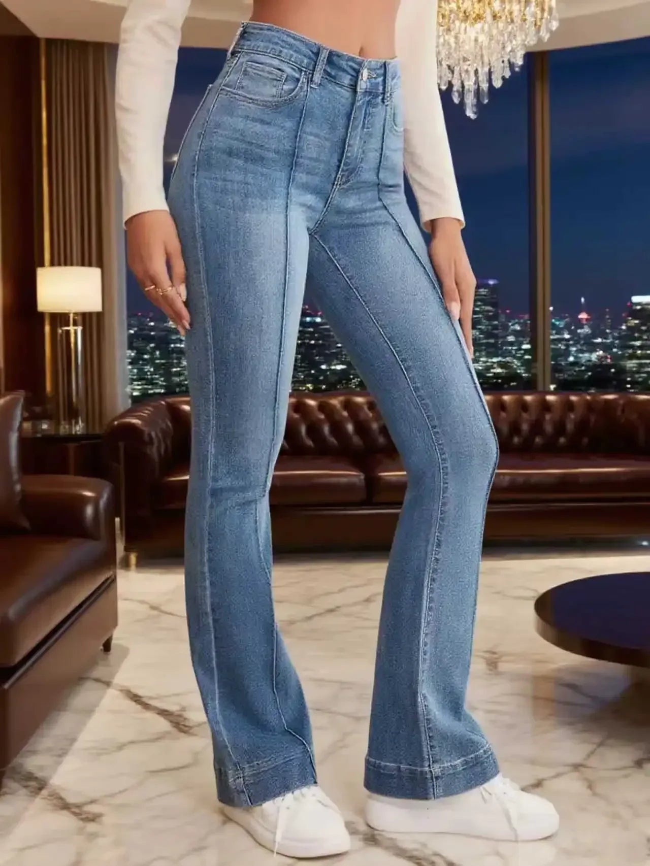 Person wearing blue jeans in a room with a cityscape view