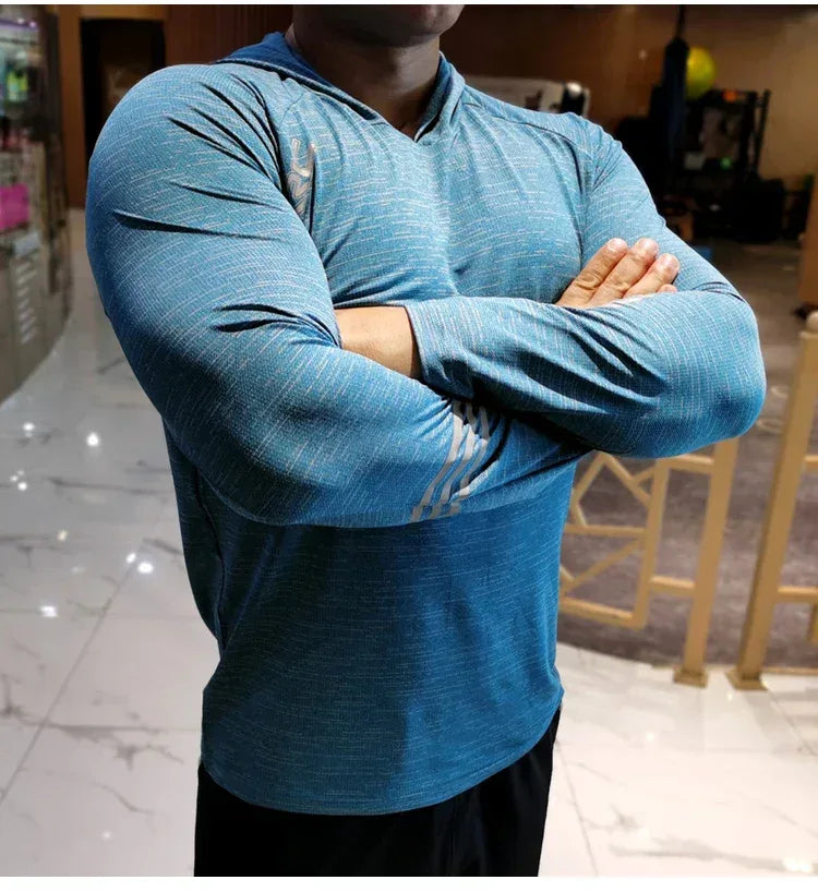 Person wearing a blue long-sleeve shirt with Adidas logo in an indoor setting