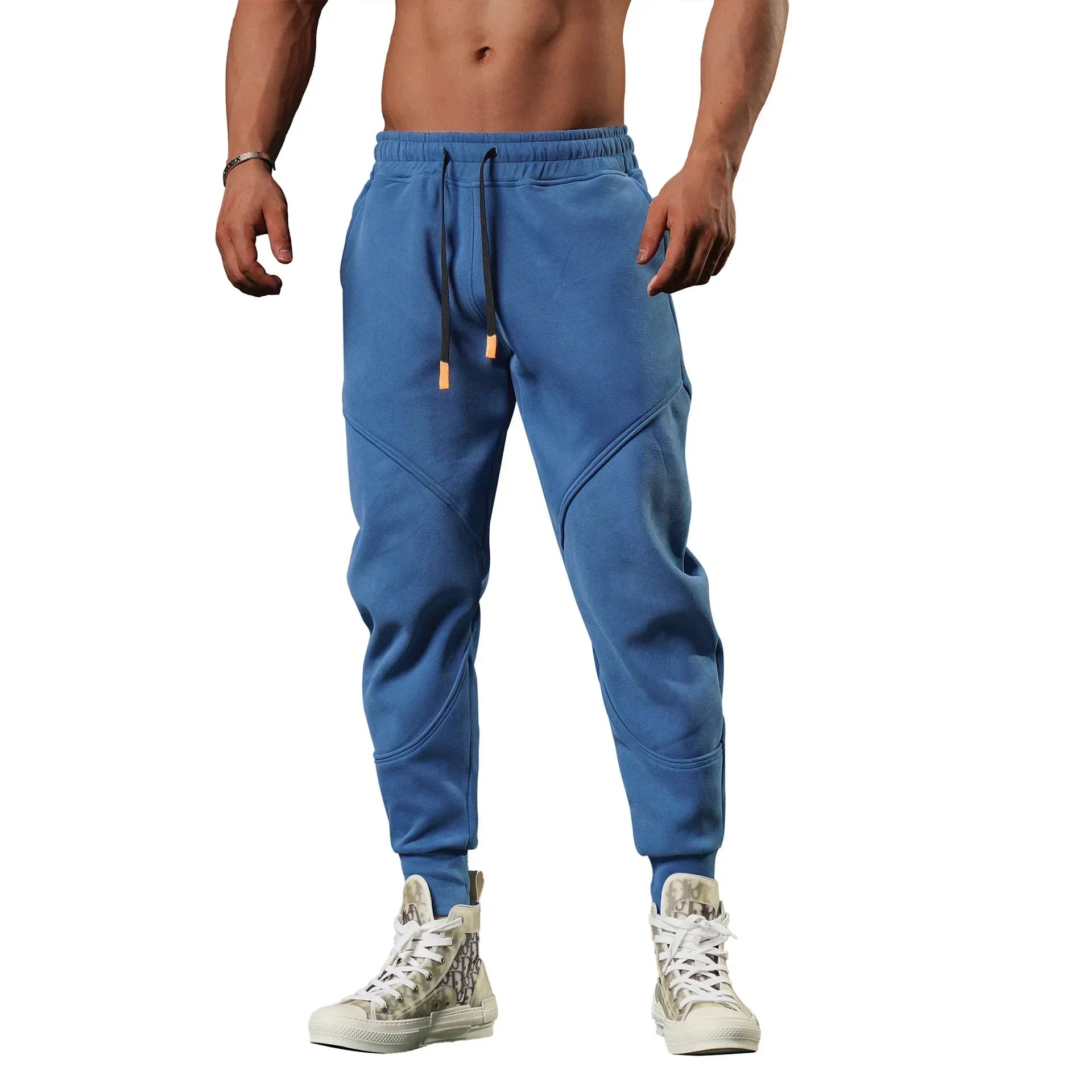 Blue jogger pants worn by a person on a white background