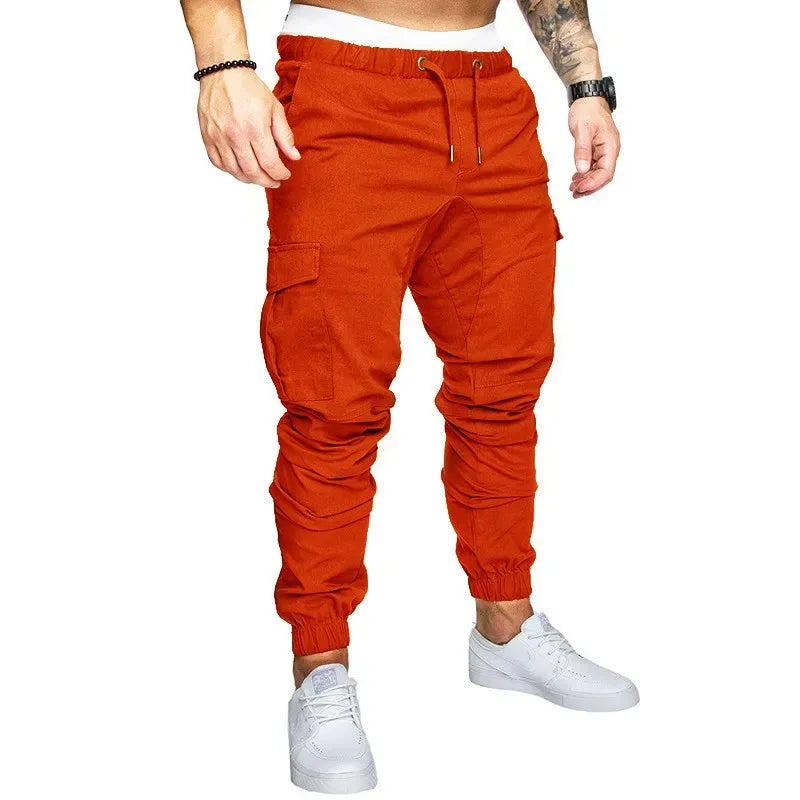 Orange cargo jogger pants worn by a person on a white background