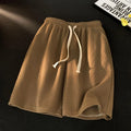 Brown shorts with a drawstring on a dark background