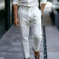 Person wearing white pants and a light-colored shirt on a blurred street background