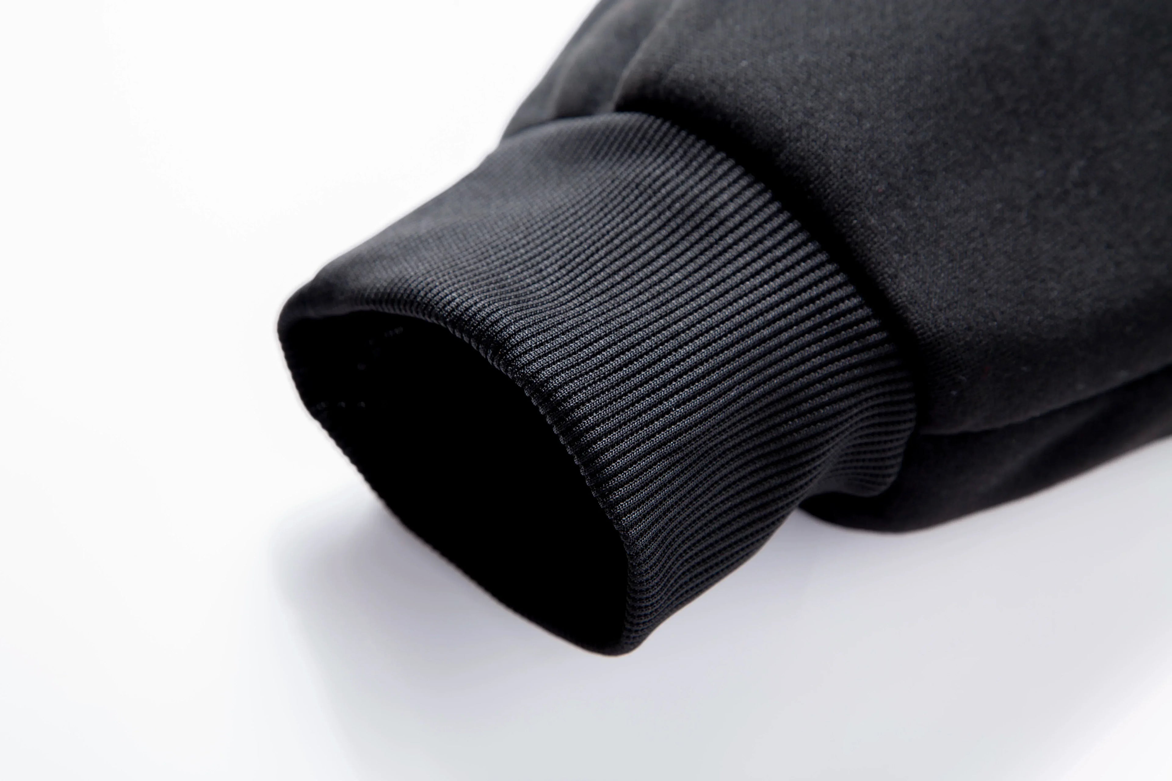 Close-up of a black sweater sleeve on a white background