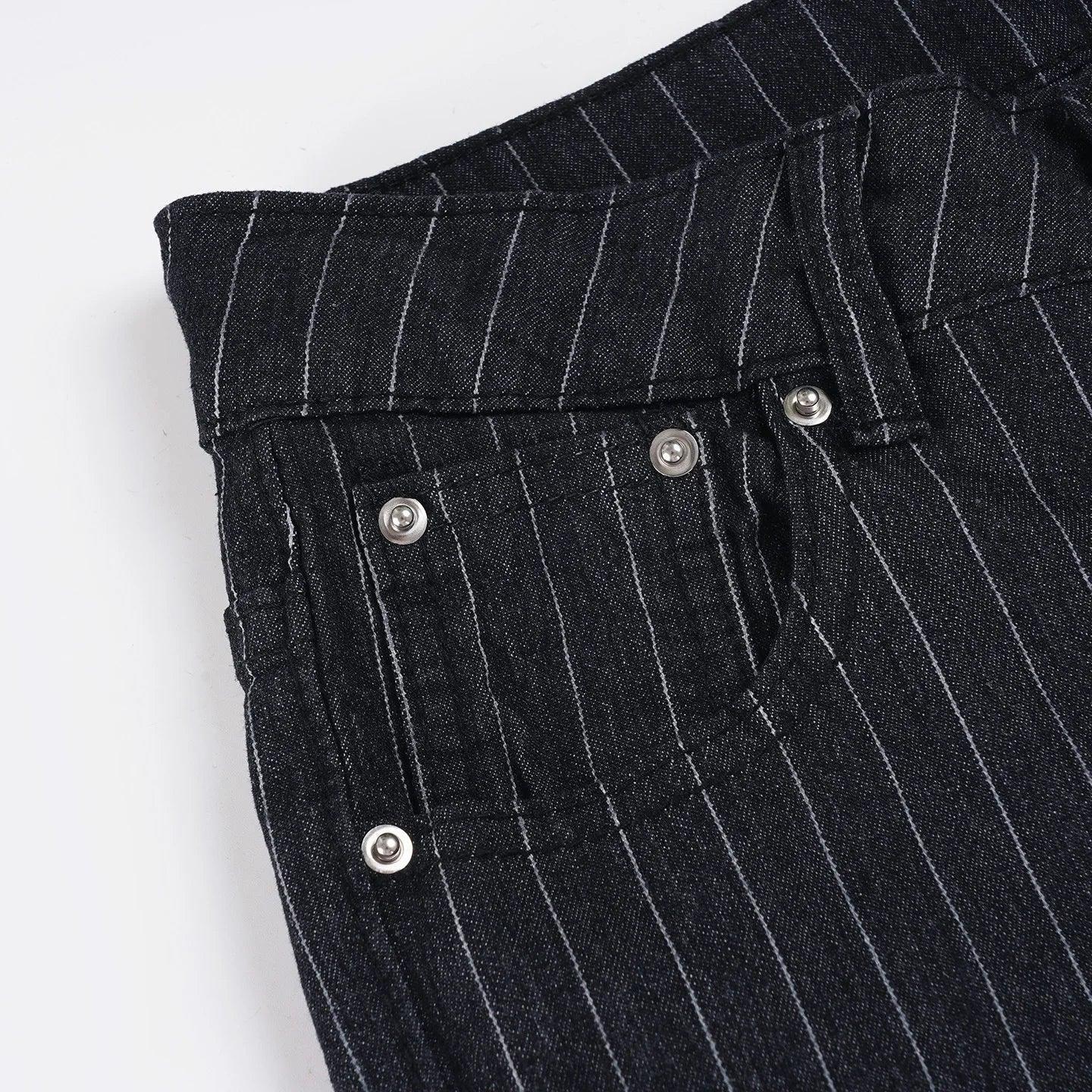 Close-up of black pinstripe pants with silver buttons on a white background