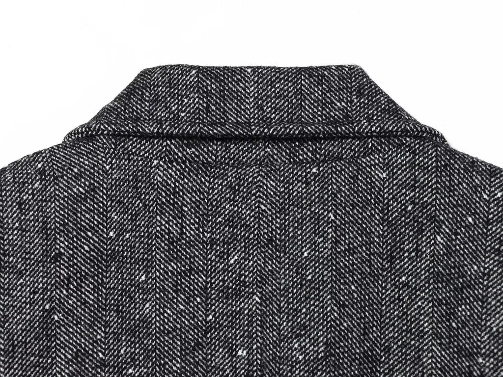 Close-up of a textured black and gray fabric with a collar