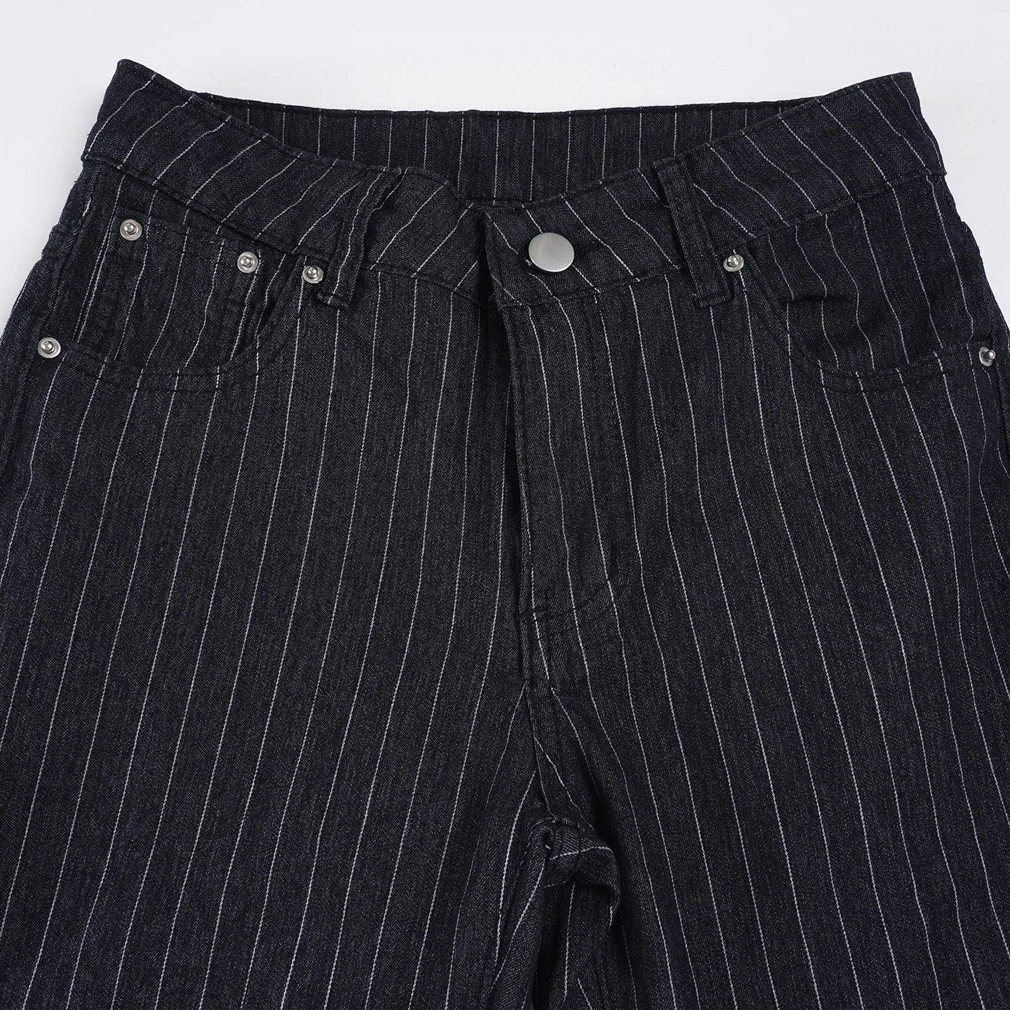 Close-up of black pinstripe pants with button details on a white background