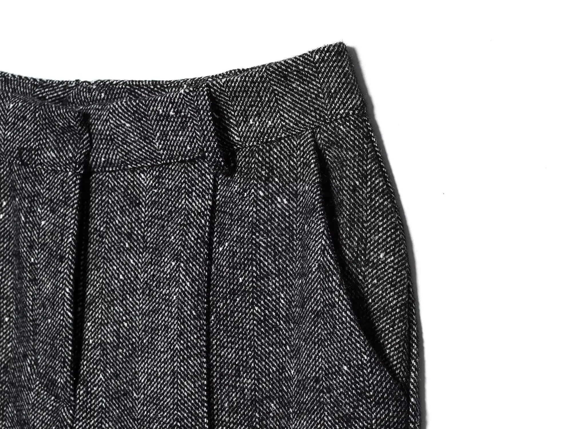 Close-up of a textured gray fabric with pleats on a white background