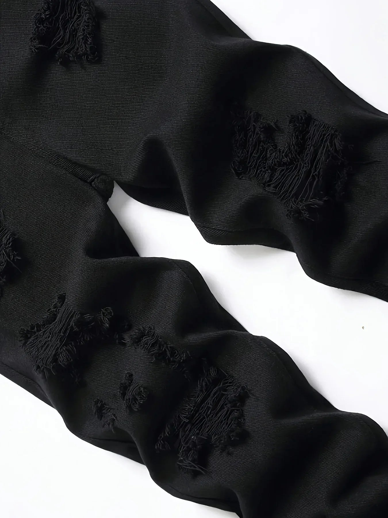 Black fabric with frayed edges on a white background