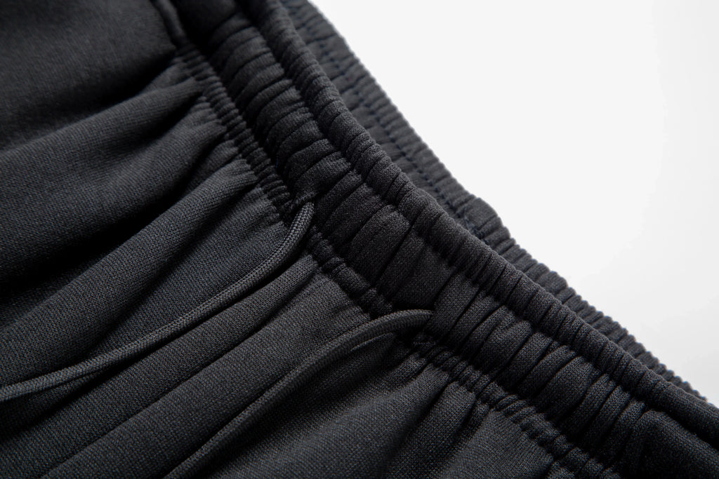 Close-up of black pants with a white background