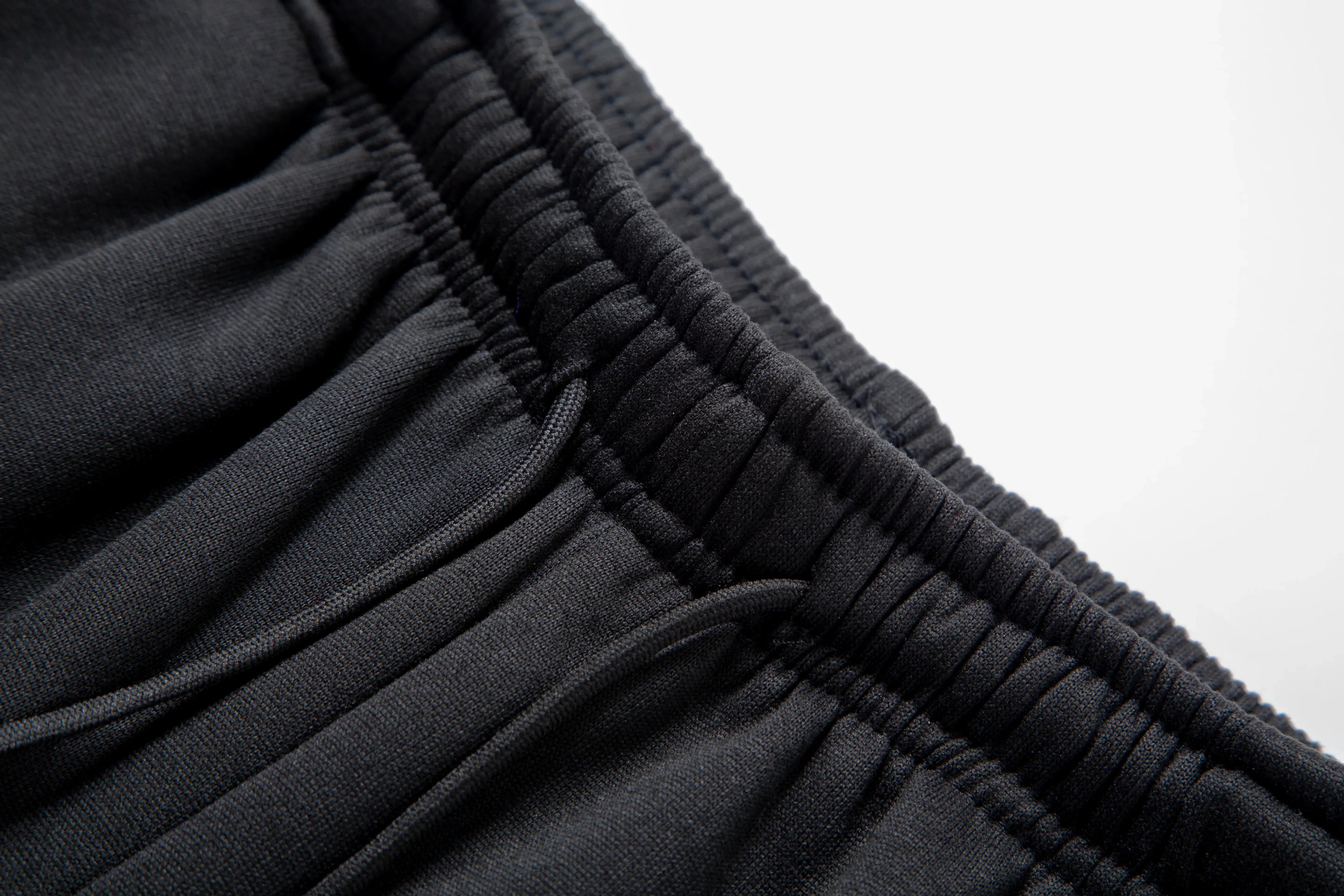 Close-up of black pants with a white background