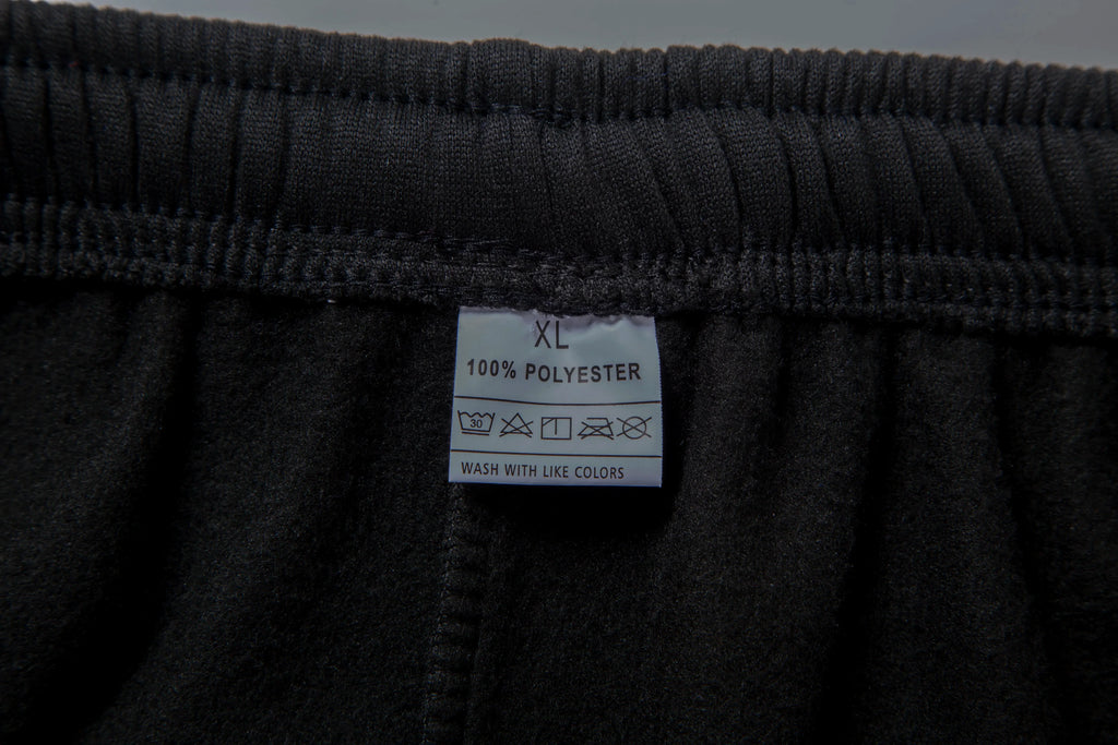 Close-up of a black garment with a label indicating size XL and material 100% polyester.