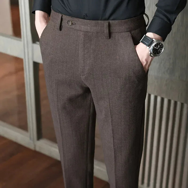 Person wearing brown dress pants with a blurred indoor background