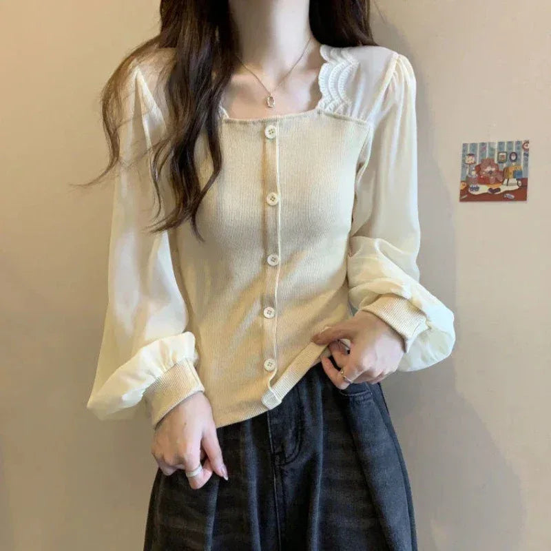 Person wearing a light-colored blouse with ruffled details against a plain background