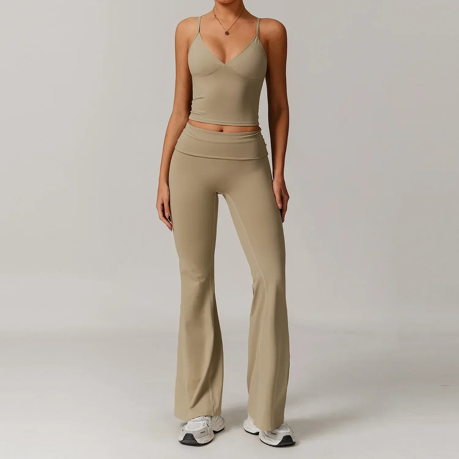 Woman wearing a cream v-neck tank top and high waisted flared yoga pants in ivory seamless fabric for a slimming athleisure outfit - BetterPlace