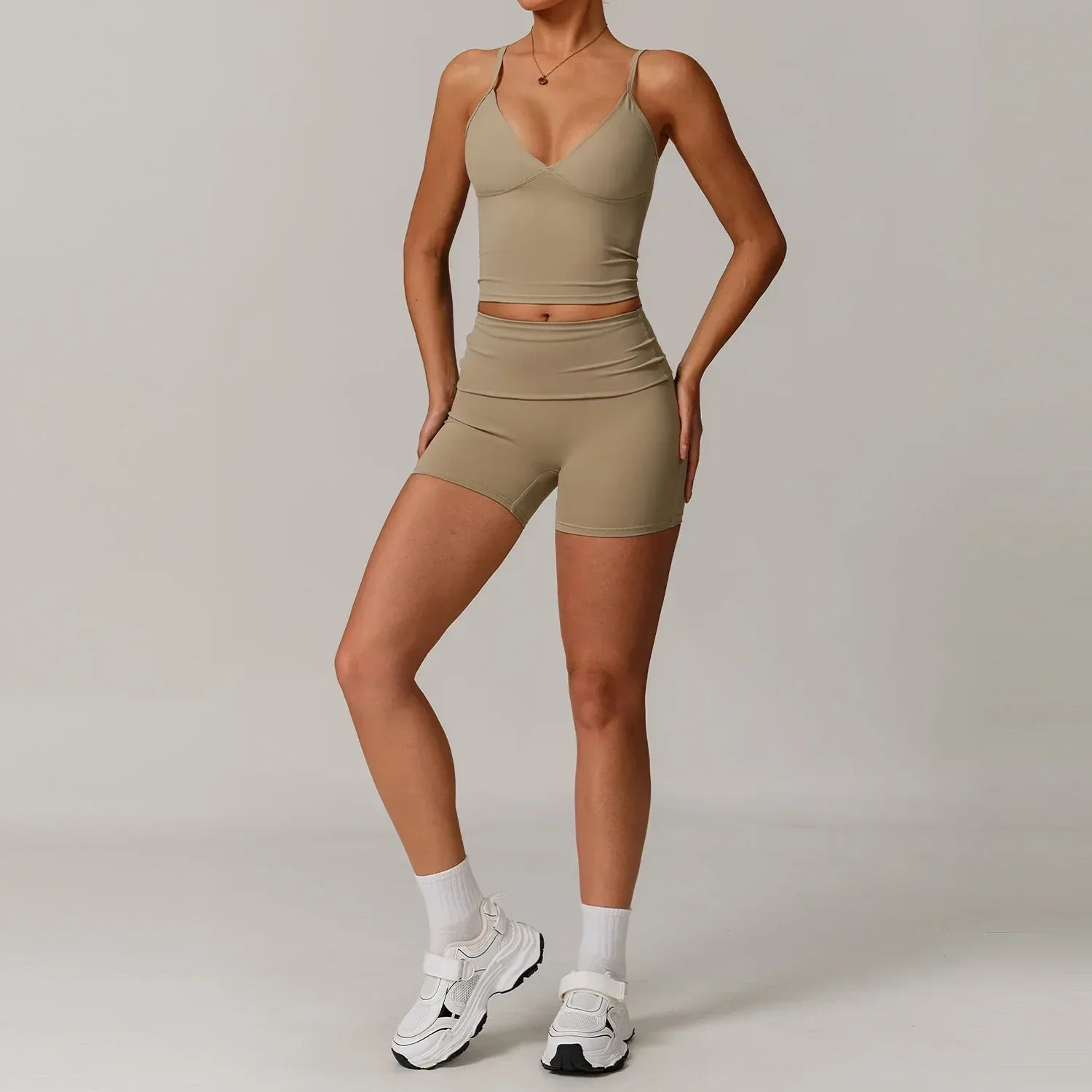Woman wearing a cream v-neck tank top and high waisted seamless workout shorts in ivory for a minimalist athleisure set - BetterPlace