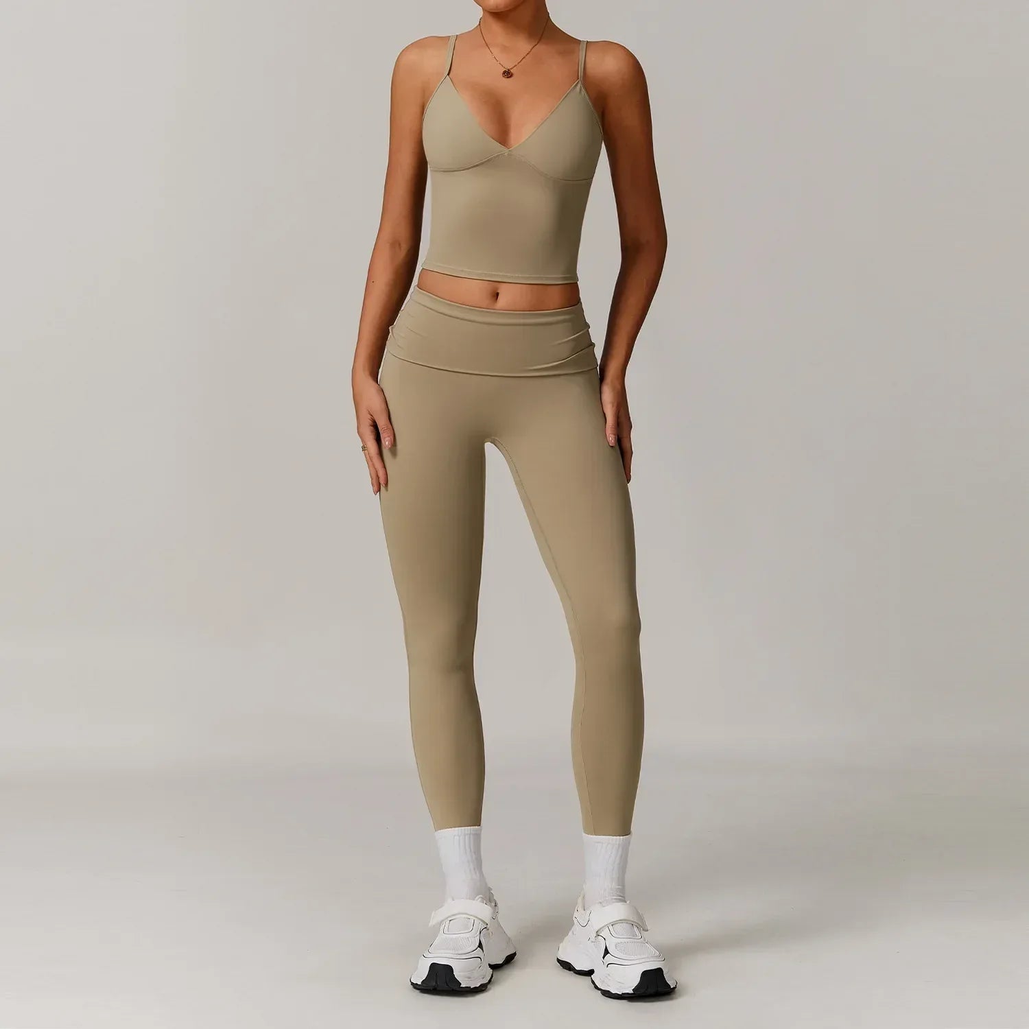 Woman wearing a cream v-neck tank top and high waisted tight leggings in ivory seamless fabric for a slimming workout outfit- BetterPlace