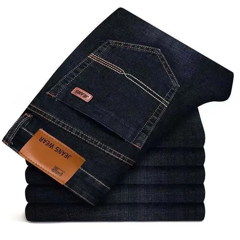 Stack of dark blue jeans with a visible brand label on a white background