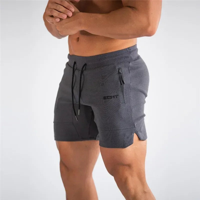 Person wearing gray shorts with a brand logo on a light gray background