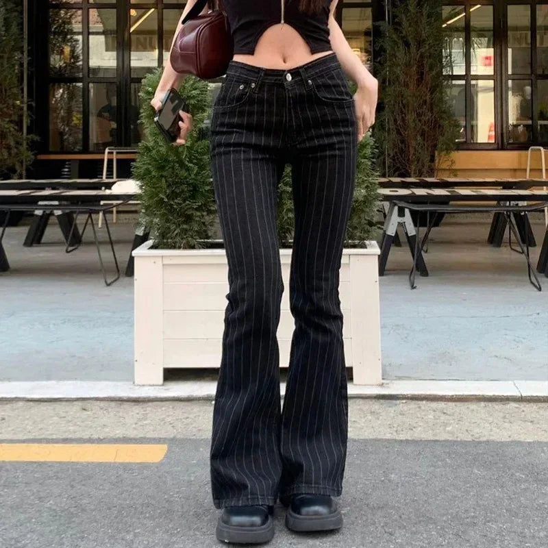 Person wearing black pinstripe flared jeans outdoors on a city street.