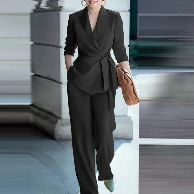 Woman in a black suit holding a brown bag in an urban setting