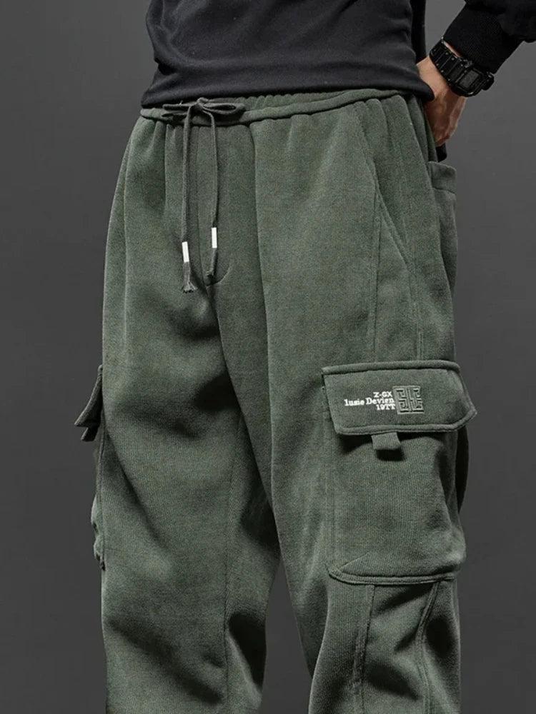 Green cargo pants with a brand logo on a gray background
