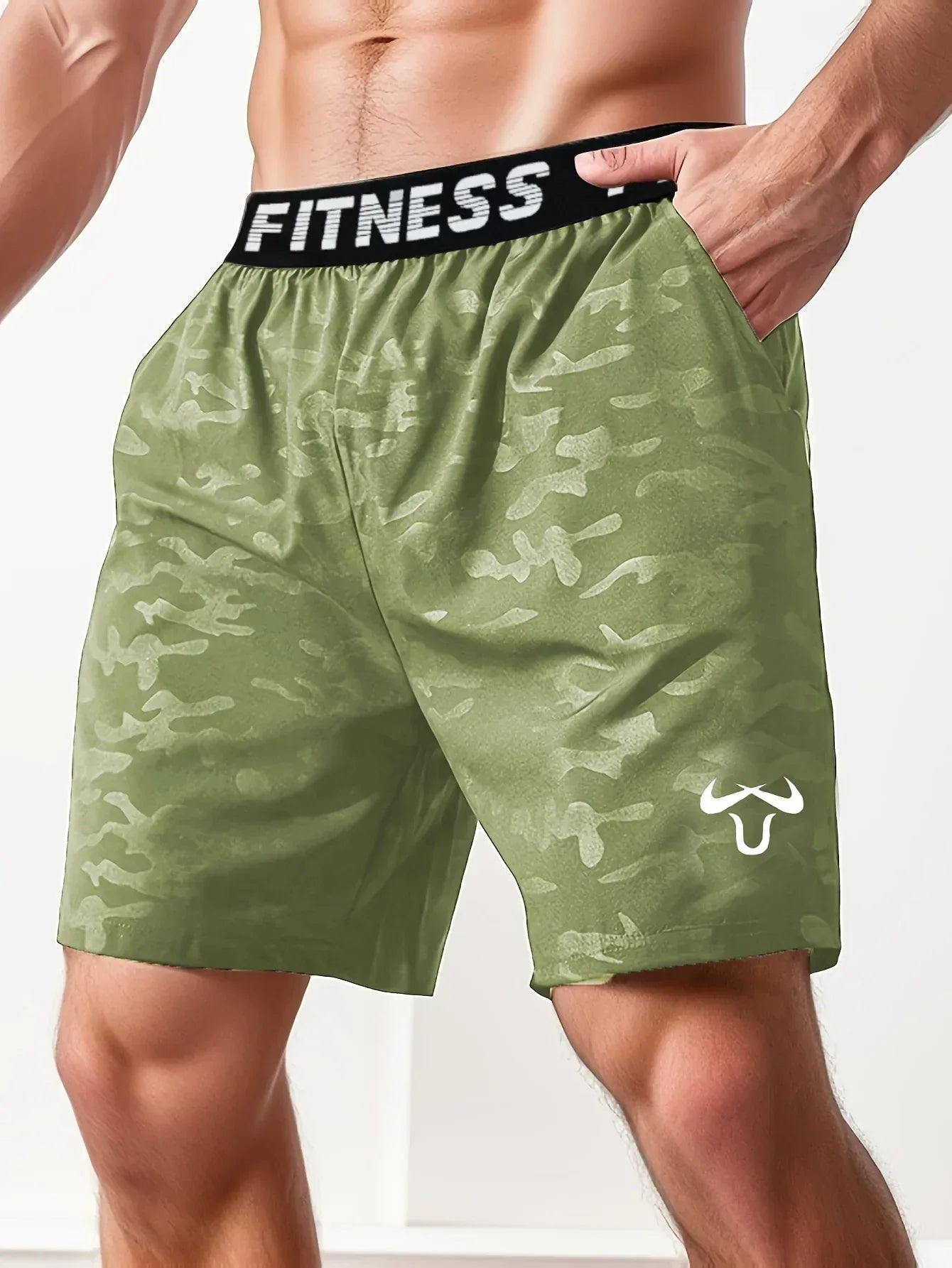 Green camouflage shorts with a 'Fitness' waistband on a person against a white background