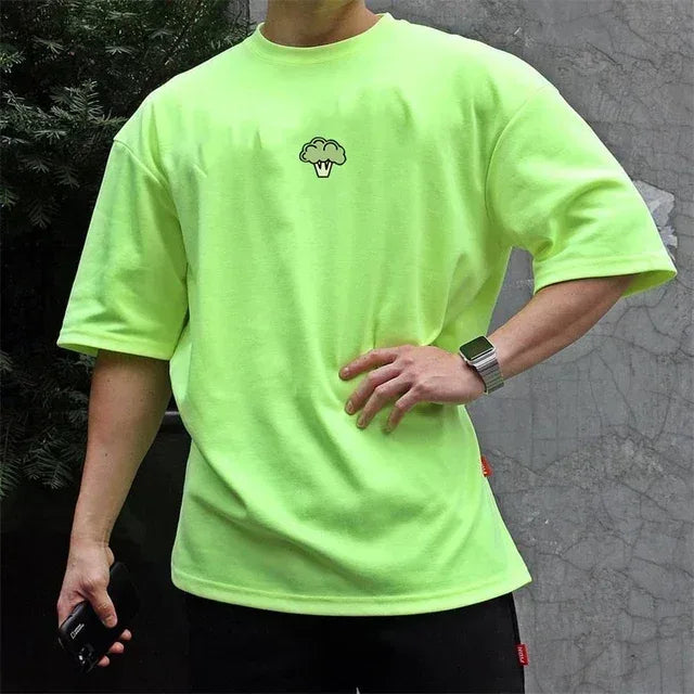 Person wearing a bright green t-shirt with a small logo on a gray background