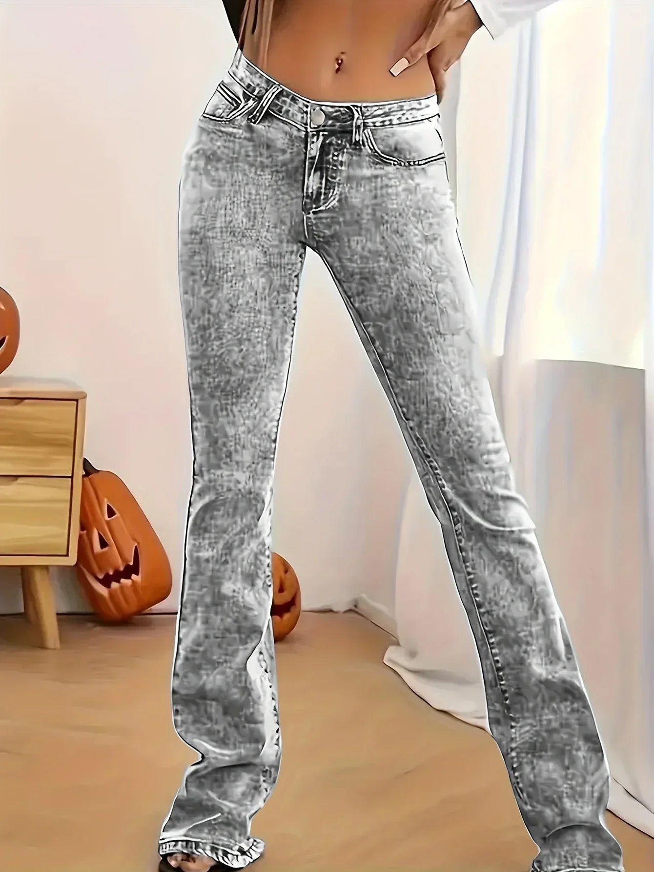 Person wearing acid-wash jeans in a room with pumpkins and a wooden cabinet.