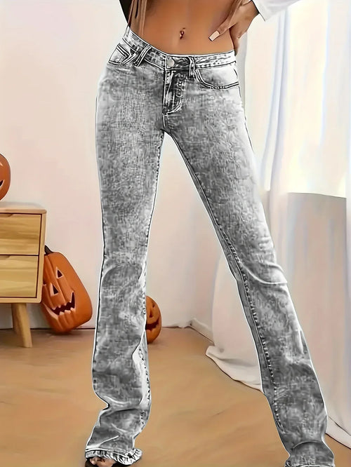 Person wearing acid-wash jeans in a room with pumpkins and a wooden cabinet.