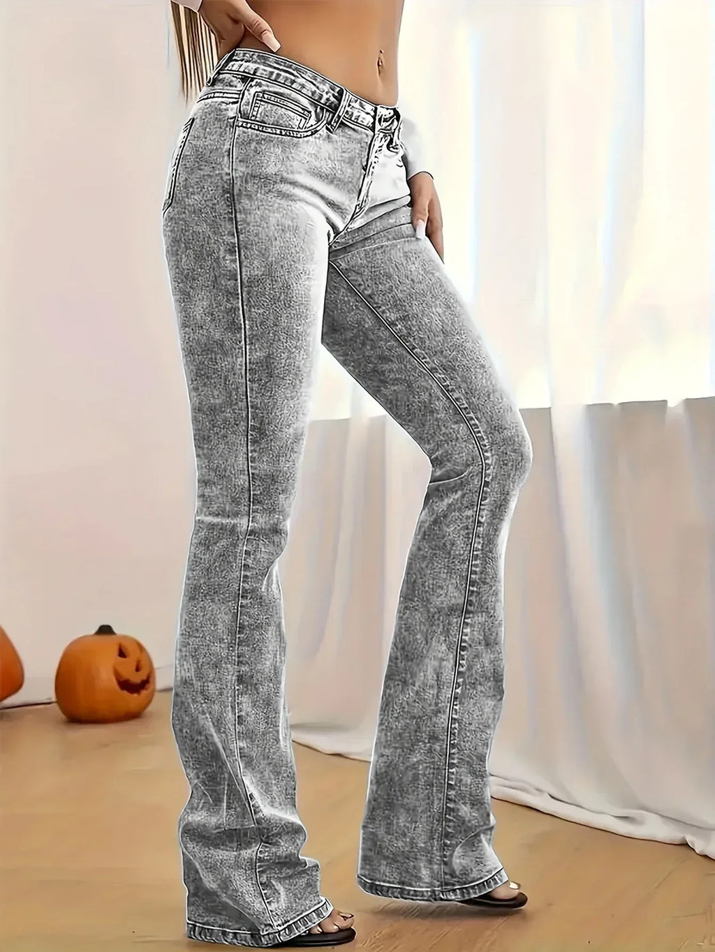 Person wearing acid-wash jeans in a minimal indoor setting