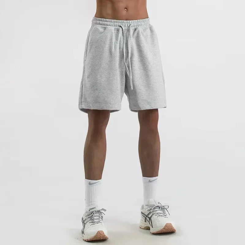 Person wearing gray shorts on a white background