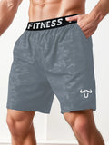 Gray camouflage shorts with a black 'Fitness' waistband on a person against a white background