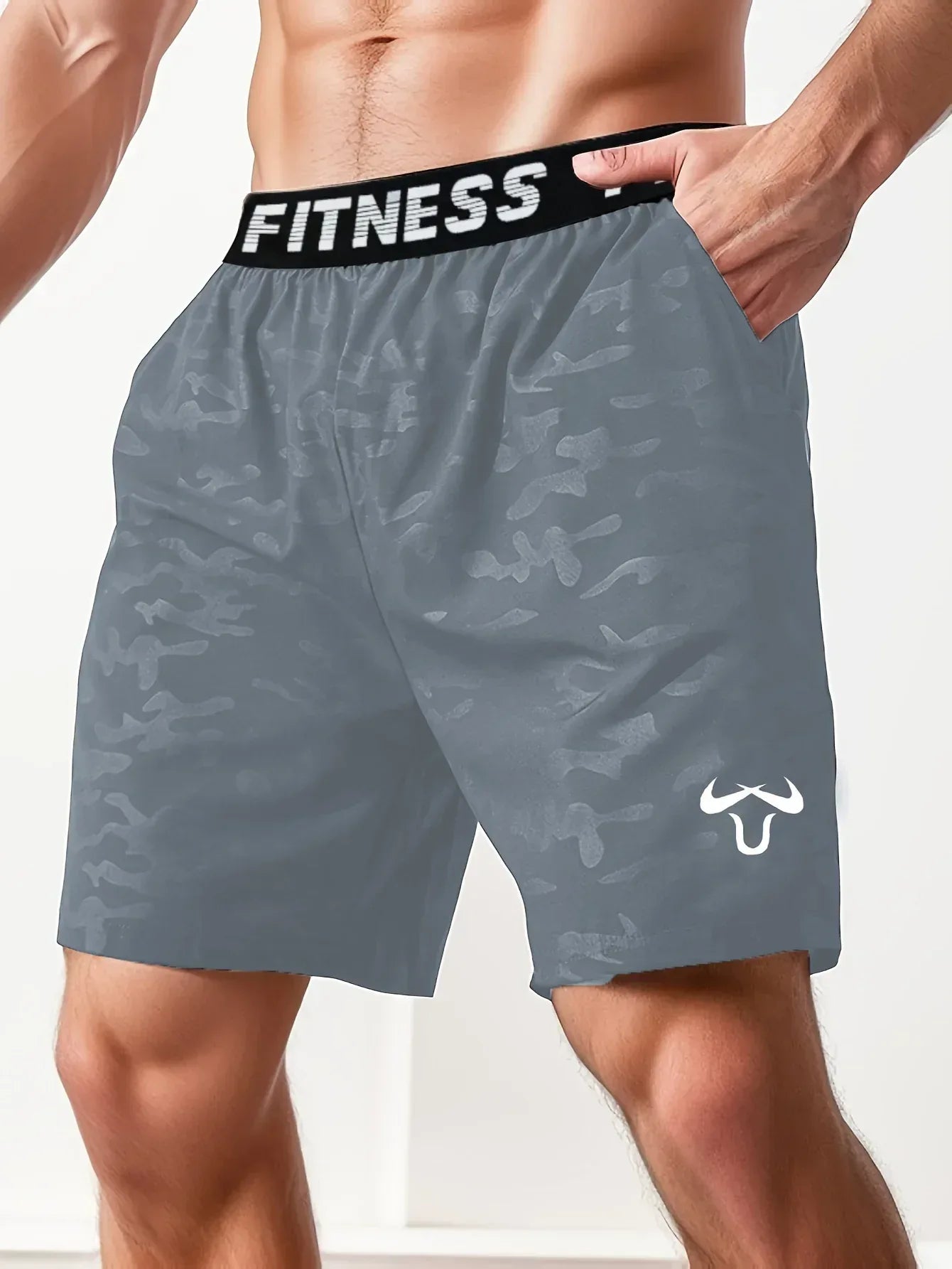 Gray camouflage shorts with a black 'Fitness' waistband on a person against a white background