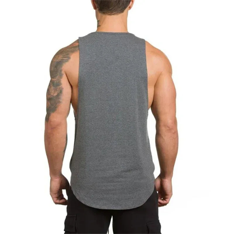 Person wearing a gray sleeveless shirt on a white background