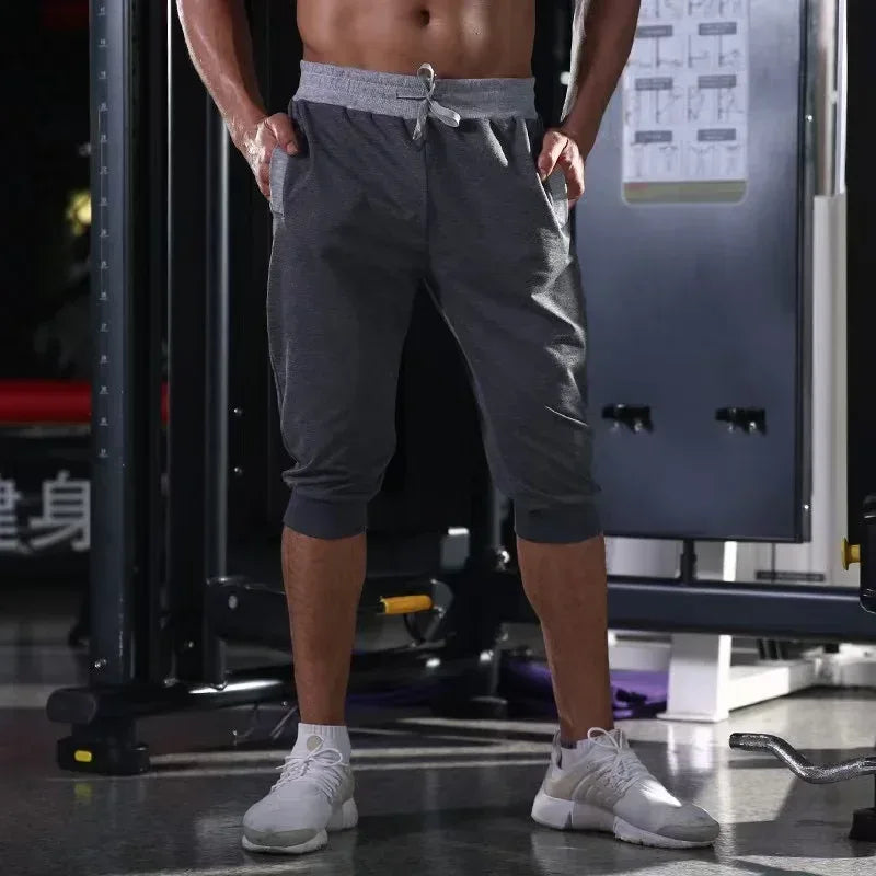 Person wearing gray athletic shorts in a gym setting