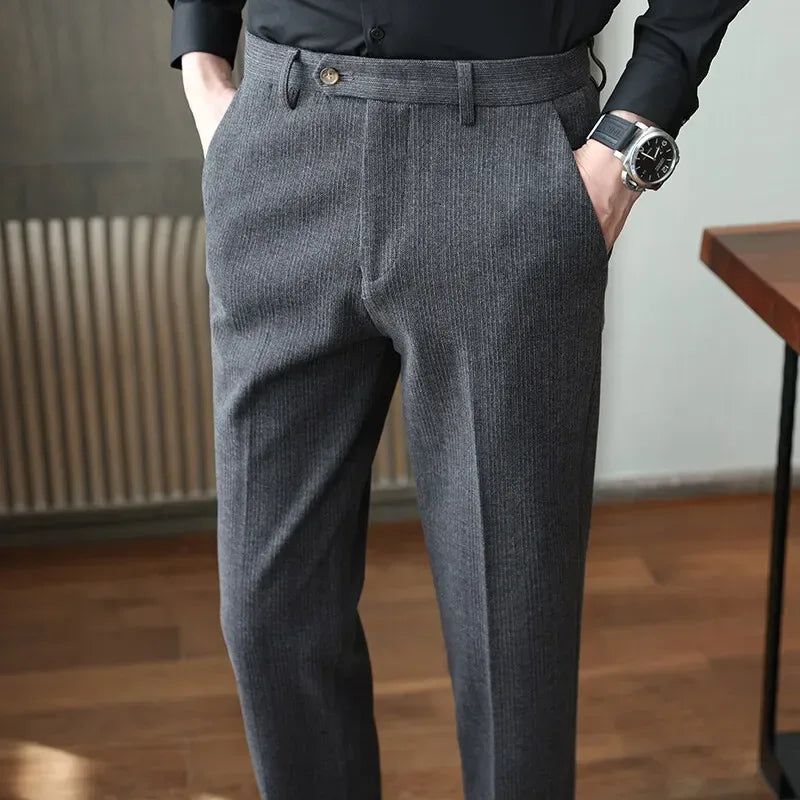 Person wearing gray herringbone trousers with a blurred background