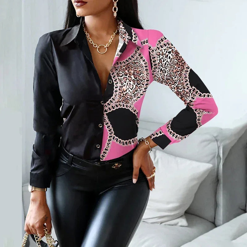 Woman wearing a black, pink, and leopard print blouse in a living room setting.